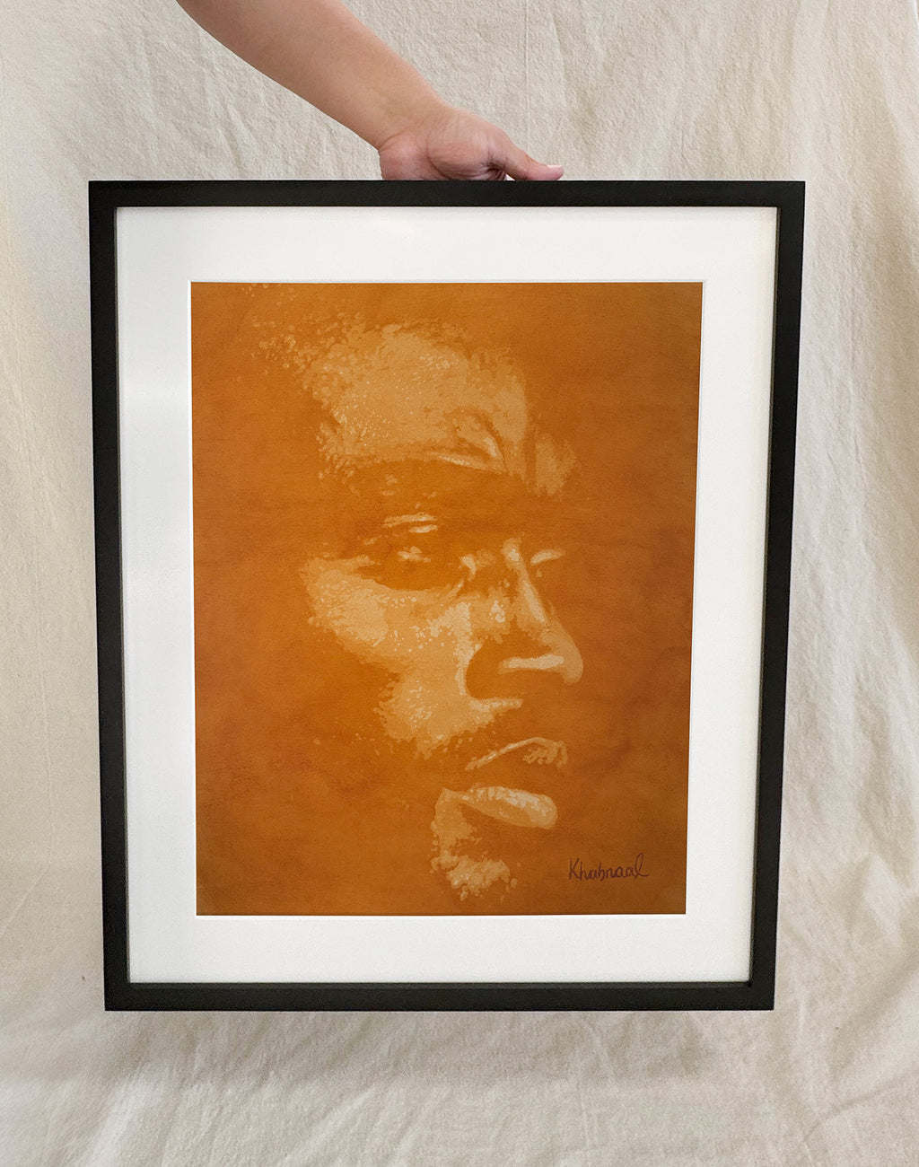 Hand shown for scale against Davon, a 15.25 × 19.25 inch original acrylic portrait